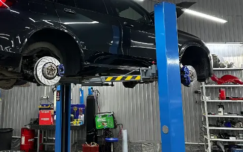 BMW со снятыми колёсами после установки тормозных дисков
