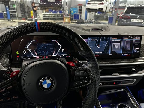 Полный вид приборной панели и центрального экрана BMW iDrive 8 с картами