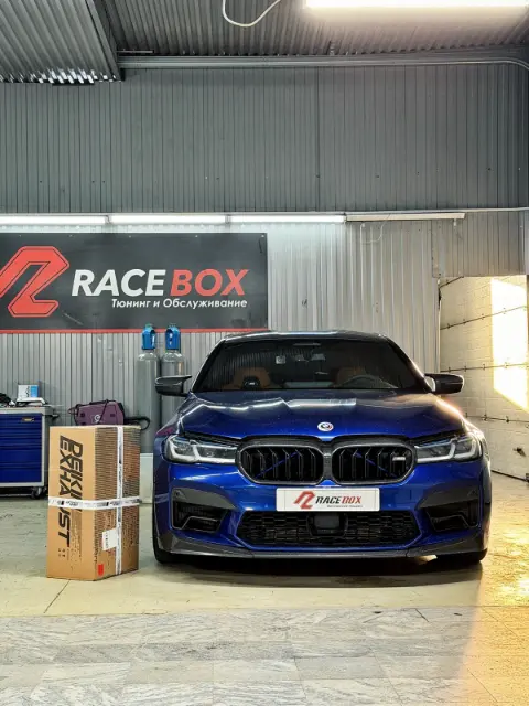 Синяя BMW M5 F90 перед установкой downpipe DEIKIN в RaceBox