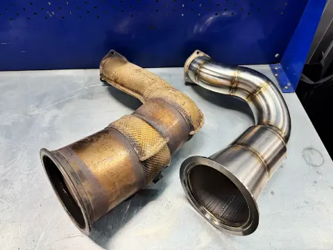 Новый downpipe Porsche Cayenne 3.0 рядом со штатной деталью